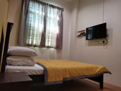 a bedroom with a bed and a tv and a window at G FORTUNE HOTEL + in George Town