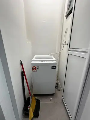 a small white refrigerator in a room with a door at SZ Home Legacy at Meritus in Perai