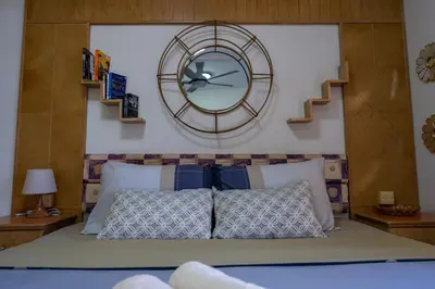 a large clock on the wall above a bed at Jemhaus Studio Sunset Seaview [Netflix & Cuckoo] in Lumut