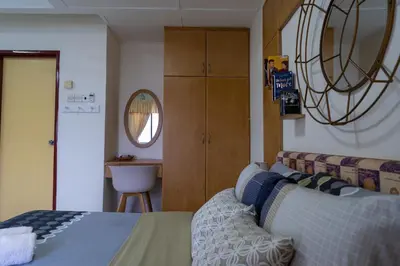 a bedroom with a bed and a couch and a mirror at Jemhaus Studio Sunset Seaview [Netflix & Cuckoo] in Lumut