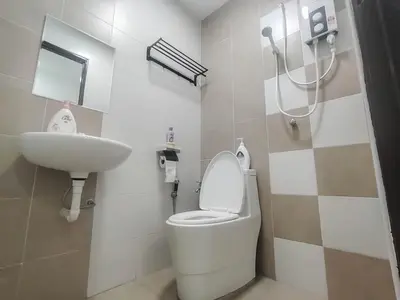 a bathroom with a toilet and a sink at Samudera Seri Manjung Residences by Manhattan Group in Kampong Pundut