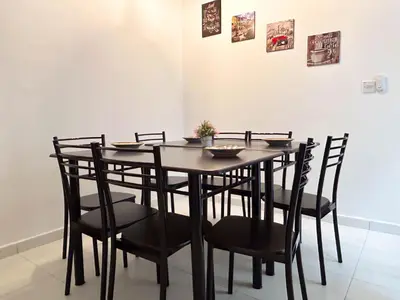 a dining room table with black chairs and a table and chairsktop at Samudera Seri Manjung Residences by Manhattan Group in Kampong Pundut