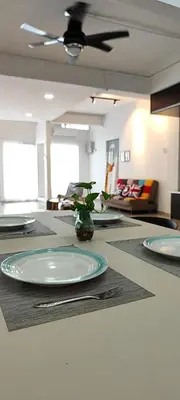a dining room table with plates and a ceiling fan at Minimaliste Ipoh Garden 2 minute to stadium 5BR5BR in Ipoh