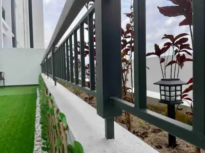 a balcony with a green railing with plants on it at The Horizon @ Ipoh - Cozy Condo with Balcony Patio in Ipoh