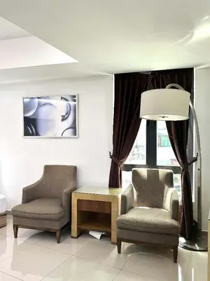 a living room with two chairs and a coffee table at Jovial Boutique Hotel```` Kampung Baru in Bukit Mertajam
