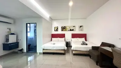 a bedroom with two beds and a couch in it at Jovial Boutique Hotel```` Kampung Baru in Bukit Mertajam