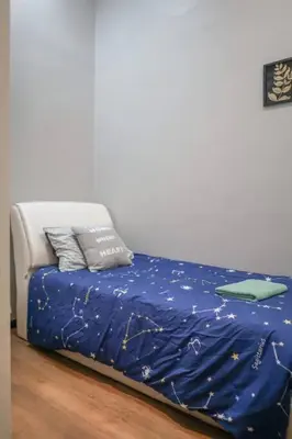 a bed with a blue comforter and two pillows at MODERN HERITAGE HOUSE``````Georgetown\u4e54\u6cbb\u5e02 in George Town