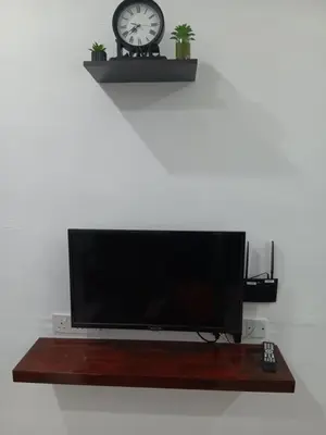 a flat screen tv with a clock on a wall at WY Impian Homestay in Bukit Mertajam