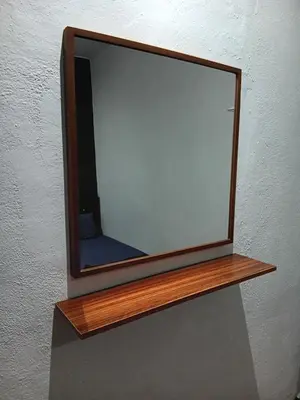 a mirror with a wooden frame on a wall at WY Impian Homestay in Bukit Mertajam