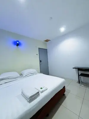 a bedroom with a white bed with towels on it at Asia Green Hotel in Sungai Besar