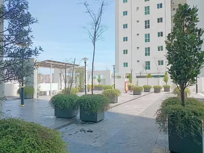 a courtyard with potted trees in front of a building at Deluxe Suites 4, 2-5 pax, Netflix, Georgetown in Jelutong