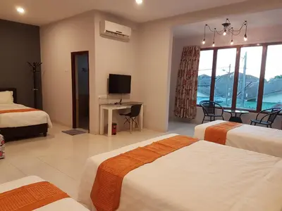 a hotel room with two beds and a television at White House Homestay in Ipoh
