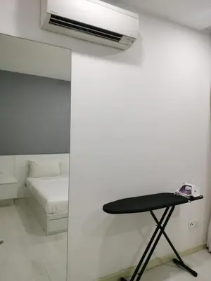 a room with a bed and a table in it at Strait Garden Family Suites by Maj in Jelutong