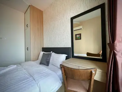 a bedroom with a bed with a mirror and a chair at The Majestic Ipoh Town - Mountain View in Ipoh