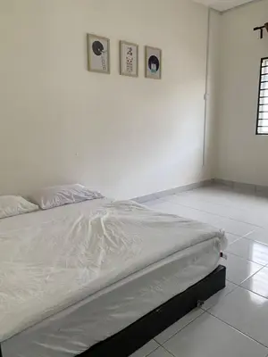 a bed in a white room with three pictures on the wall at Juwita&Arjuna Homestay Teluk Senangin in Kampong Batu Tiga