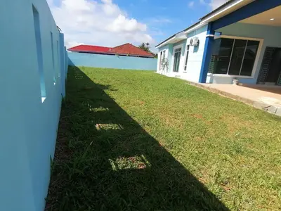 a shadow of a building on the grass next to a building at Marvelous Homestay SP Kedah in Sungai Petani