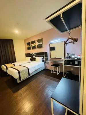 a large hotel room with a bed and a desk at K Garden Hotel Parit Buntar in Parit Buntar