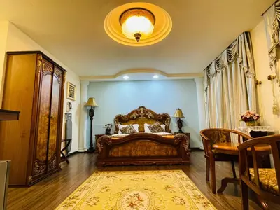 a bedroom with a large bed and a table at K Garden Hotel Parit Buntar in Parit Buntar
