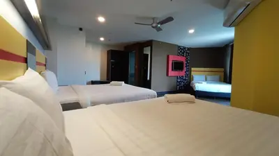 a hotel room with two beds and two beds sidx sidx sidx at Sense Hotel Taiping in Taiping