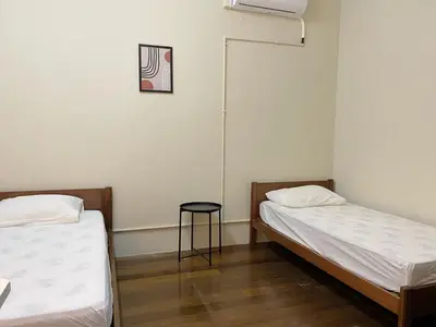 a room with two beds and a stool in it at Aayu Chulia - Chulia St, George Town in George Town