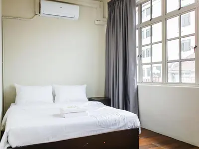 a bedroom with a bed and a large window at Aayu Chulia - Chulia St, George Town in George Town