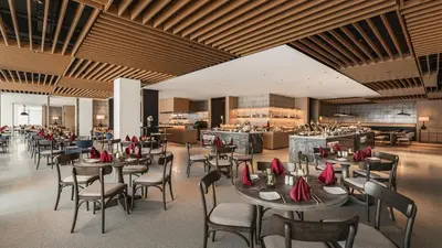 a restaurant with tables and chairs and a bar at Crowne Plaza Penang Straits City by IHG in Perai