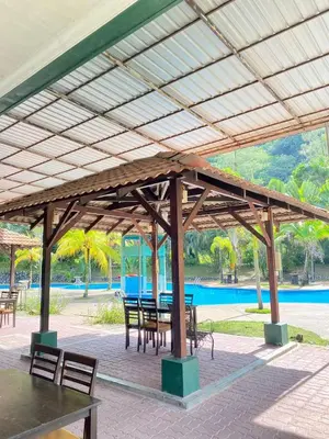 a pavilion with tables and chairs next to a pool at Teluk Batik Holiday Apartment in Lumut