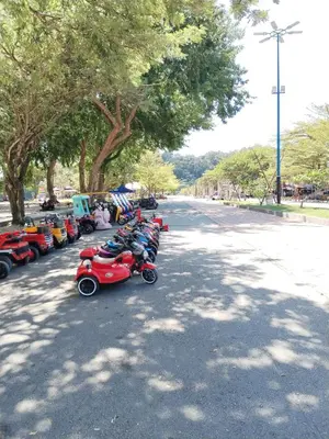 a row of small scooters parked on the side of a street at Teluk Batik Holiday Apartment in Lumut