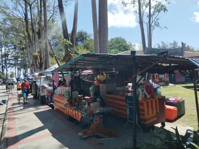 a market stand with a tiger sitting in front of it at Teluk Batik Holiday Apartment in Lumut