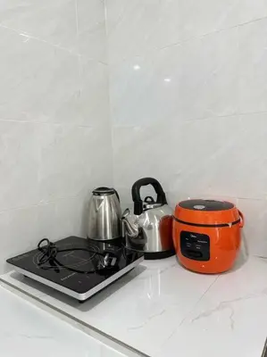 an orange toaster and a tea kettle on a stove at Ipoh stadium 1min/wahkeongpark simee 18pax bungalow cottage in Ipoh