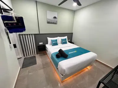 a bedroom with a large bed with blue pillows at BEATRIX HOTEL in Brinchang