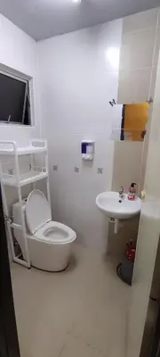 a white bathroom with a toilet and a sink at lumut manjung homestay john faten in Lumut