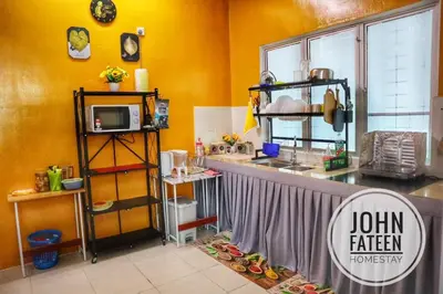 a kitchen with yellow walls and a counter with a counter top at lumut manjung homestay john faten in Lumut