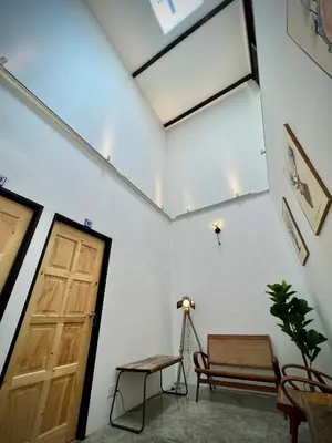 a room with a door and a bench and a table at DoSomething Guest House 3 in Ipoh