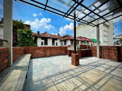 an empty courtyard with a brick wall and benches at DoSomething Guest House 2 in Ipoh
