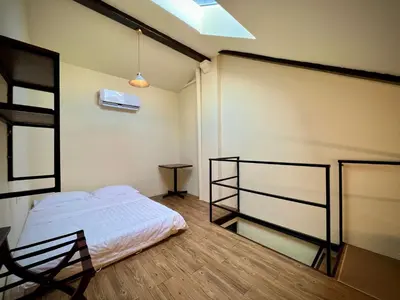 a bedroom with a bed and a table in it at DoSomething Guest House 2 in Ipoh