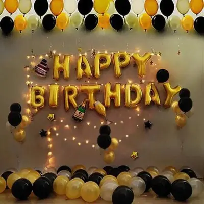 a black and gold birthday cake with a happy birthday sign at Luxury Seaview Projector Lounge by The Only Bnb in Tanjong Tokong