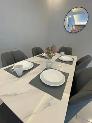 a dining room table with chairs and a mirror at Biella Homestay Apartment for Muslim in Tanah Rata
