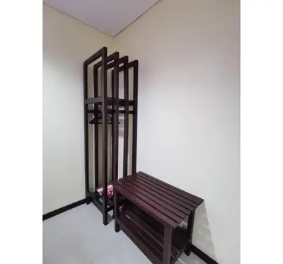 a wooden bench sitting in a corner of a room at Hotel O Pavilion Inn Hotel in Lumut