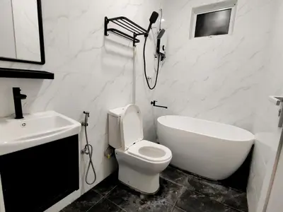 a white bathroom with a toilet and a sink at Paddy Villea Inn SPT Penang in Permatang Pauh
