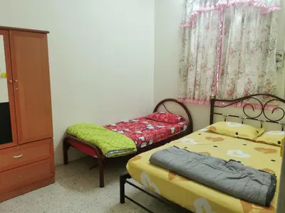 a bedroom with two beds and a dresser and a bed and a chair at Homestay Taman Mas, Kg Koh in Sitiawan