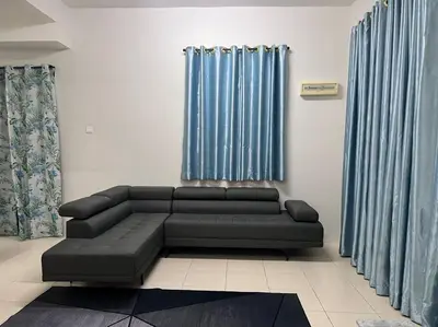 a living room with a black couch and blue curtains at D' Tronoh Home in Teronoh