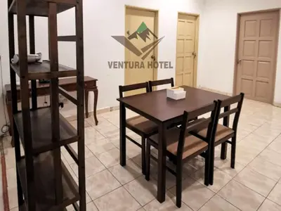 a dining room with a wooden table and chairs at Ventura Hotel and Tours in Gua Musang