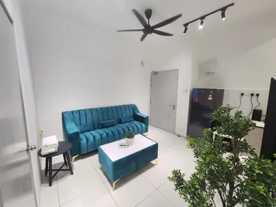 a living room with a blue couch and a table at Ipoh City Executive Suite - The Horizon in Ipoh
