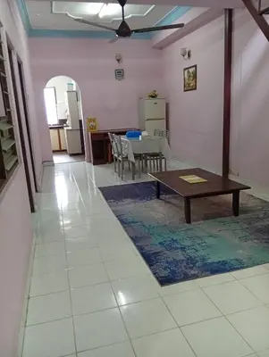 a living room with a table and a dining room at Ekaira homestay in Tambun