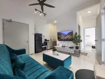 a living room with a blue couch and a table at Horizon Premium Suite - Ipoh in Ipoh