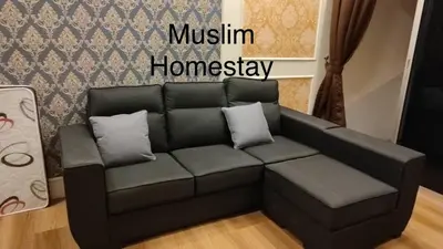 a black couch in a living room with apodcast sign at Adik Aisyah classic 2 in Cameron Highlands