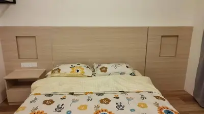 a bedroom with a bed with a headboard and two pillows at Adik Aisyah classic 2 in Cameron Highlands