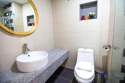a bathroom with a sink and a toilet and a mirror at The Trails of Kampar in Kampar