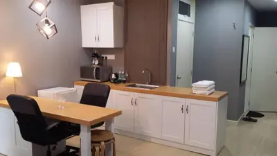 a kitchen with white cabinets and a table with chairs at Champs Elysees in Kampar